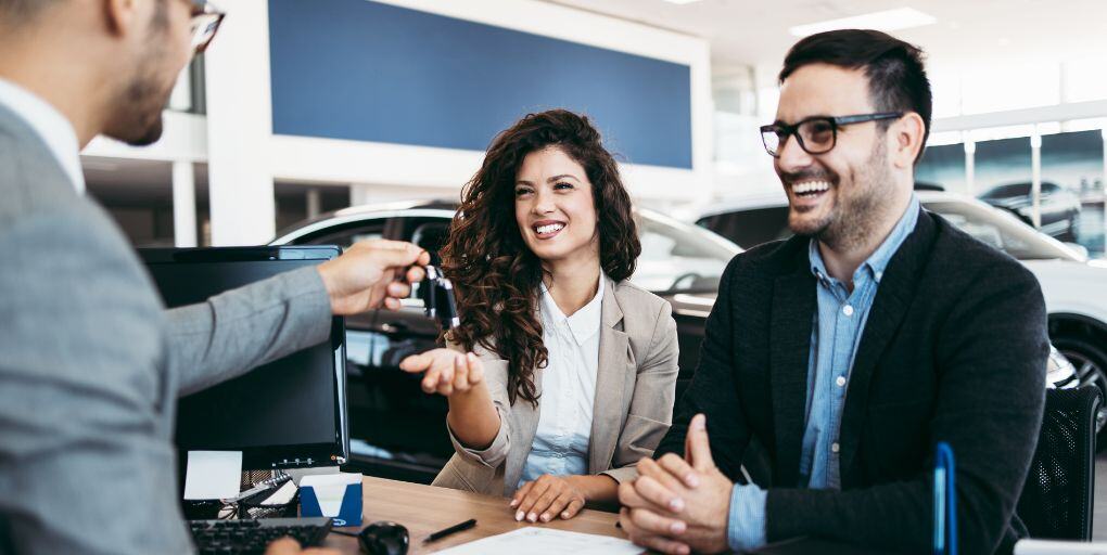car-smiling-couple-dealership-sales-shutterstock_1487497124